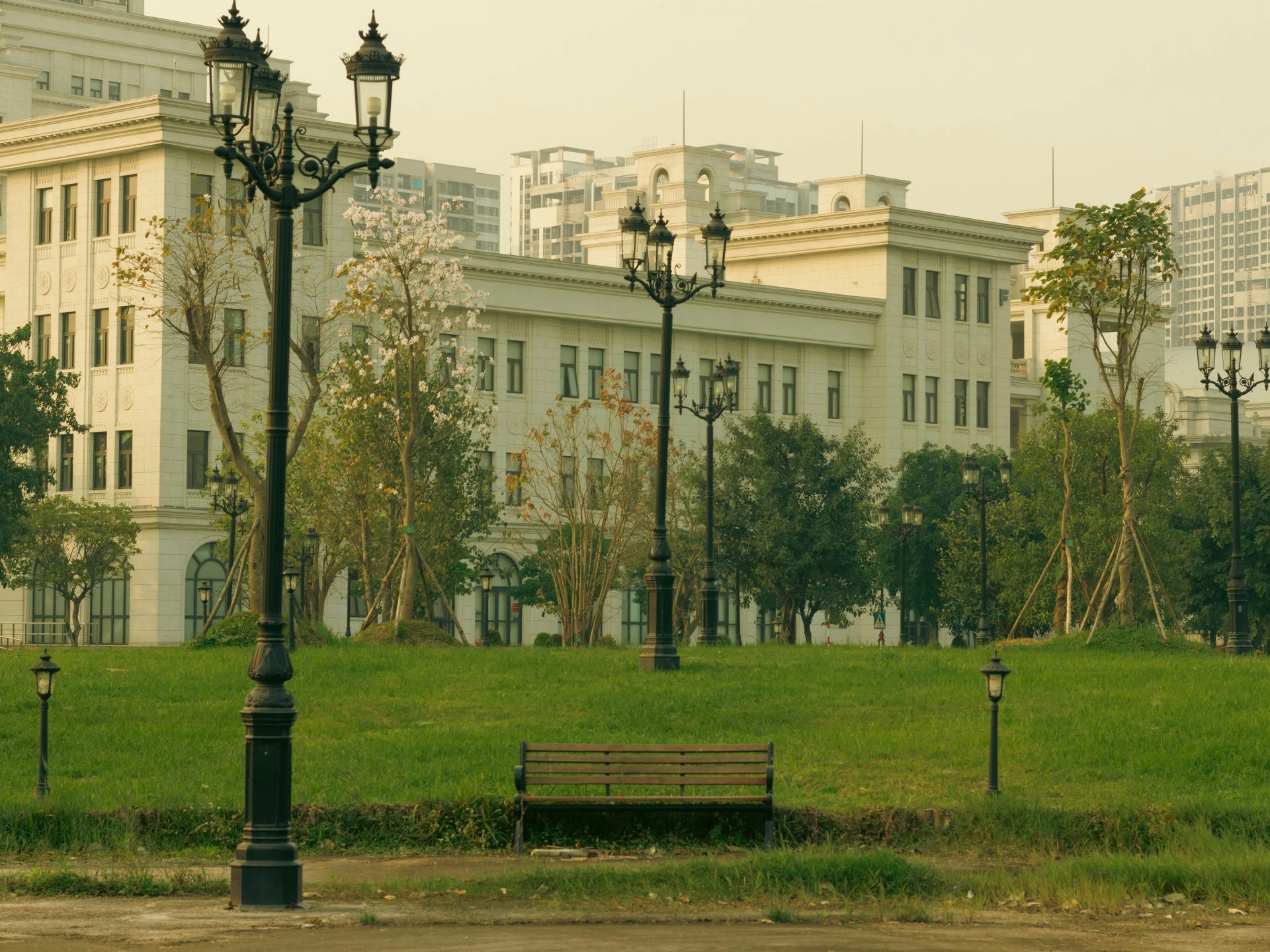 a park with a bench and street lamps
