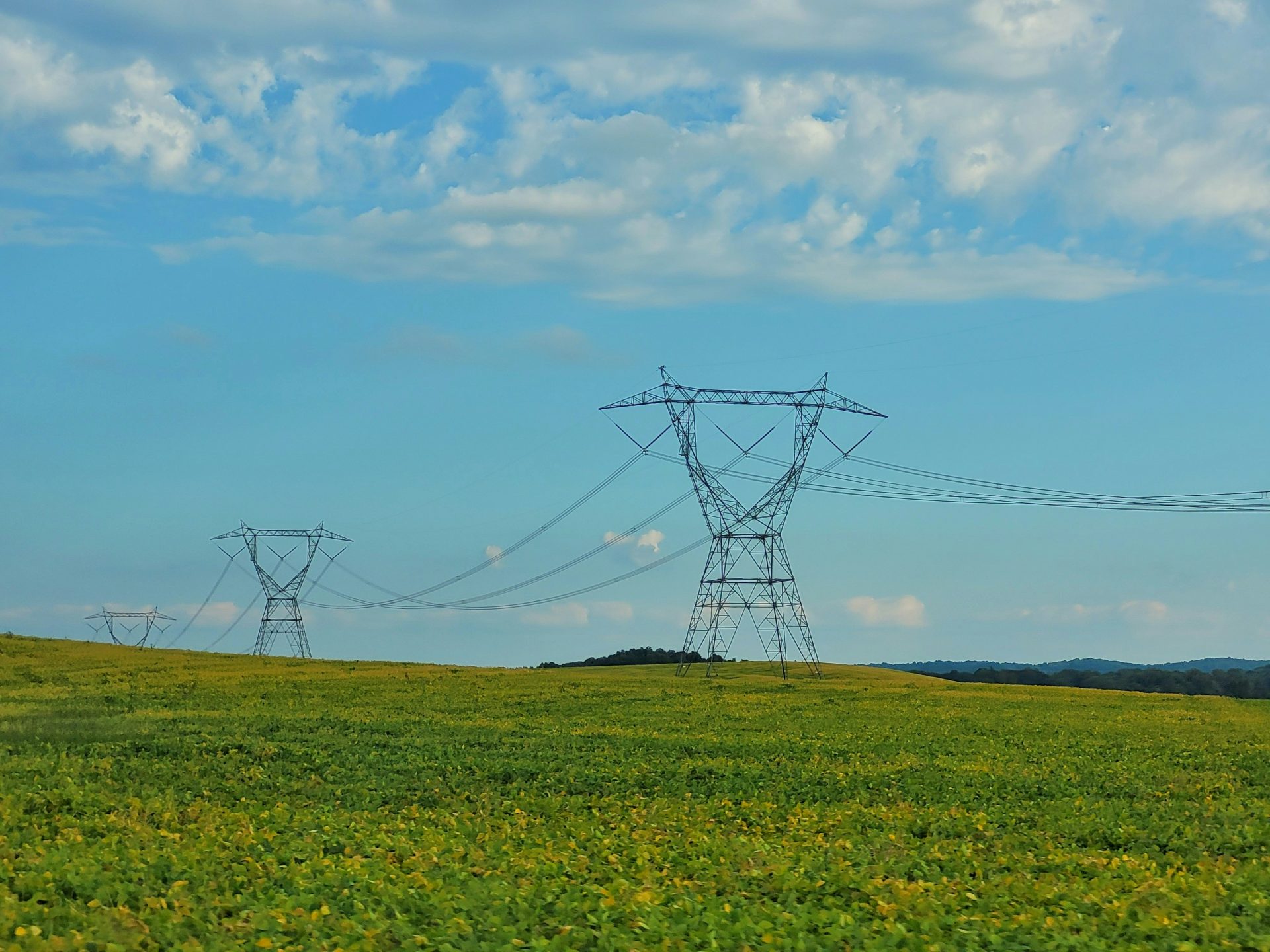 a field with power lines in the distance